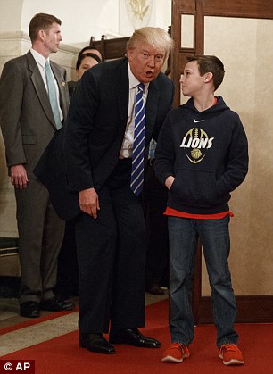 
Tổng thống Mỹ và cậu bé 10 tuổi đã chụp ảnh chung dưới bức chân dung cựu Đệ nhất phu nhân Hillary Clinton. Trước khi quay trở lại phía bên kia bức vách, ông nói với đám đông rằng mọi người hãy làm việc chăm chỉ.
