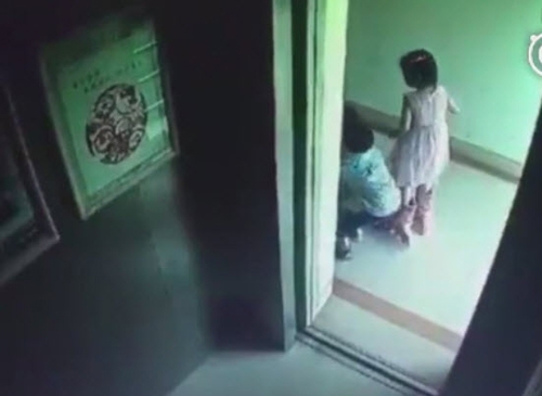 
​Bé gái 2 tuổi bị anh bế ngược vào trong thang máy.
