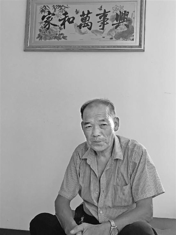 
Ông Yu ngồi trong phòng khách, nơi bức tranh của một cô con gái thêu được treo một cách trang trọng.
