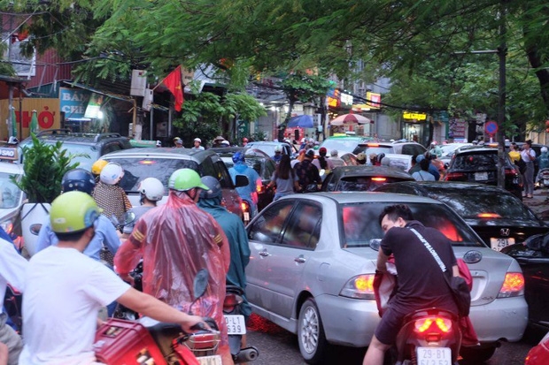 Đoạn đường hẹp càng thêm ách tắc khi xe máy, ô tô chen chân cố gắng vượt qua đám đông.