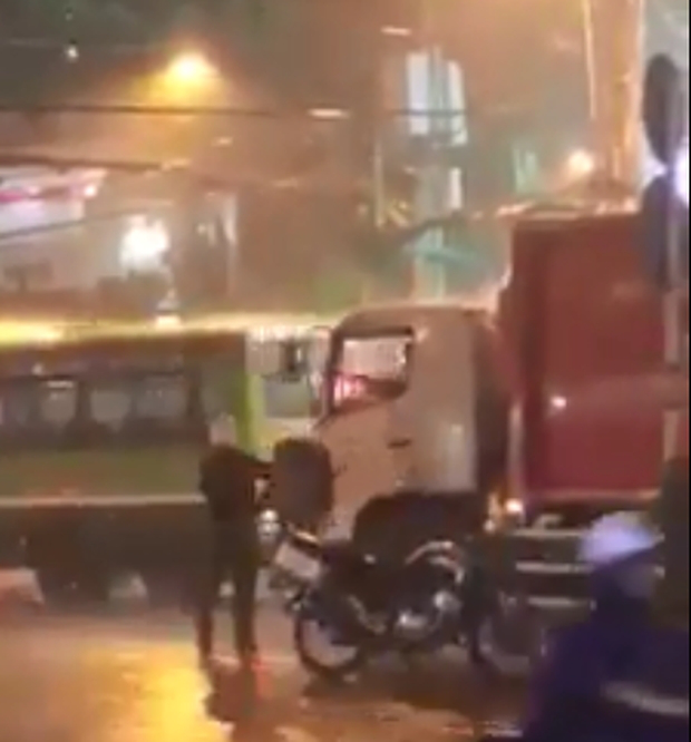 Anh CSGT nhận chiếc &aacute;o mưa từ b&aacute;c t&agrave;i. Ảnh cắt từ clip.