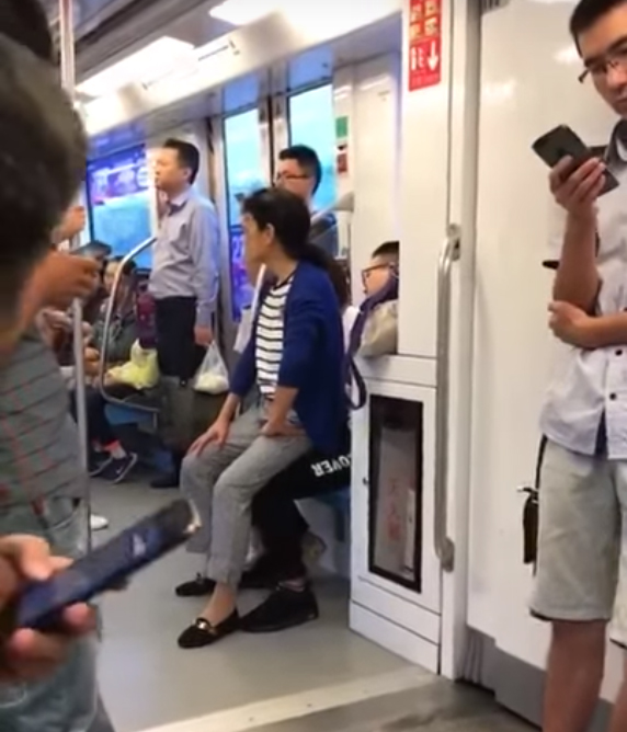 Ch&agrave;ng trai nhất quyết trong nhường ghế cho bạn g&aacute;i m&agrave; bắt c&ocirc; ngồi l&ecirc;n ch&acirc;n m&igrave;nh. (Ảnh cắt từ clip)