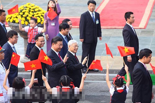 Hai nhà lãnh đạo vẫy tay với các em thiếu nhi cầm cờ Việt Nam và Trung Quốc khi di chuyển sang Văn phòng Trung ương Đảng để tiến hành hội đàm. Ảnh: Nguyễn Chương