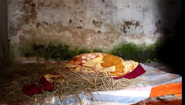 Anh Lai cuộn mình trong chăn. Tuy vẫn còn chút trí nhớ về người thân nhưng hành động của anh không khác gì trẻ con.