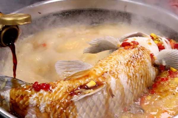 Bước 4: Đậy nắp lại và nấu cá khoảng 15-20 phút, sau đó rắc thêm hành lá và rau mùi xắt nhỏ lên. Khi trình bày bạn để nguyên phần nước sốt cay cho món ăn thêm đậm đà.