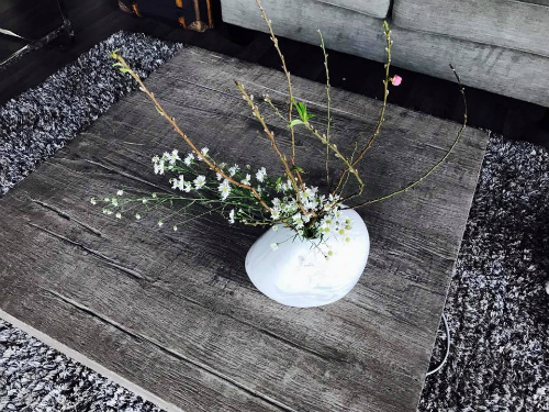 Ngày Tết không thể thiếu hóa đào giúp nuôi dưỡng ấm khí dương xuân. Hồng Nhung thích chơi những cành đào mini khiêm nhường nhưng có dáng uốn cong mềm mại, tỏa khối tròn. Cô kết hợp cùng vài nhánh thạch thảo trắng và cắm theo phong cách Ikebana Nhật Bản - một cách sáng tạo đậm nét Á đông.