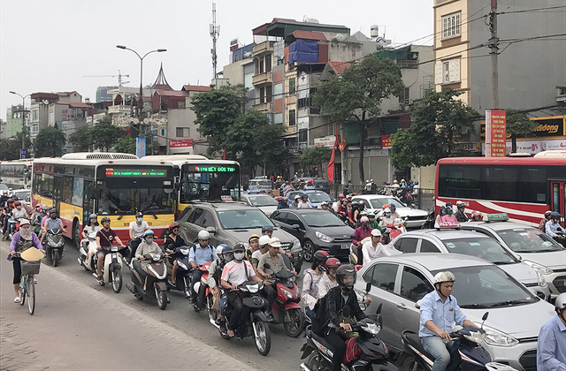 
Người điều khiển ô tô, xe máy chen nhau đi trên đường trong cảnh ùn tắc, người điều khiển xe máy bị ô tô chèn ép không còn lối đi trên đường Giải Phóng
