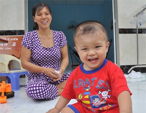 Bé Dương Minh Phát tươi cười bên mẹ
