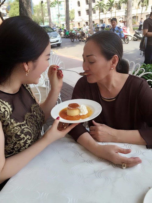 
Lý Nhã Kỳ đút cho mẹ ruột ăn bánh flan trong một cửa hàng ở vỉa hè Sài Gòn.
