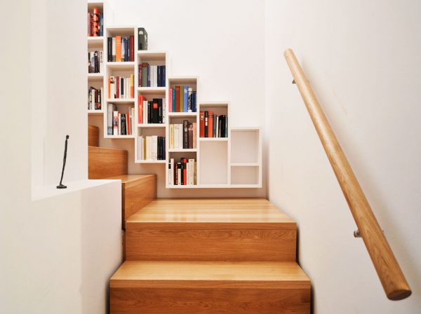 7. Những ô lưu trữ nhỏ của tủ sách mini được gắn lên bức tường màu trắng, tương phản với màu gỗ của cầu thang, tay nắm cầu thang hình trụ tròn là điểm nhấn đáng chú ý.