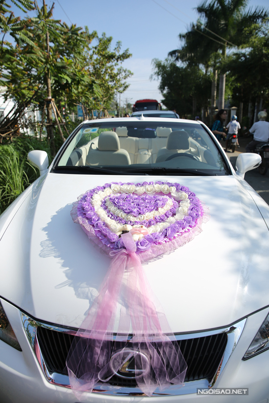 
Chiếc xe mui trần được trang trí vòng hoa hình trái tim có tone màu tím, màu chủ đạo của đám cưới.
