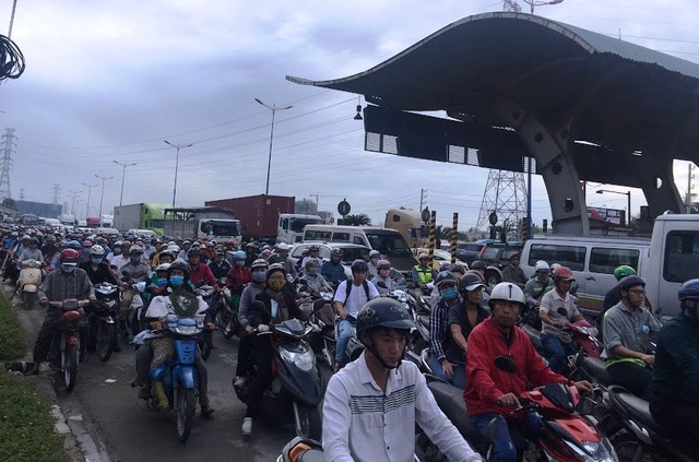 Dòng xe máy chen nhau vượt qua khu vực kẹt xe trên xa lộ Hà Nội vào sáng 7/6.