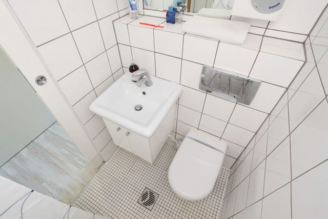 Nhà vệ sinh nhỏ nhưng rất ngăn nắp và sáng sủa, sạch sẽ với nền gạch sáng.