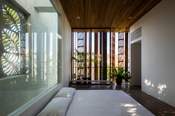 Phòng ngủ chính với các tấm cửa gỗ xoay họa tiết lá, vừa giúp giữ lại sự riêng tư, vừa giúp phòng thông thoáng và kiểm soát được lượng ánh sáng tự nhiên.