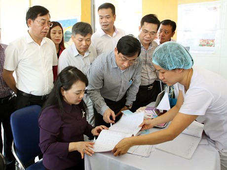 
Bộ trưởng Bộ Y tế kiểm tra sổ khám thai tại trạm Y tế xã Mai Đình, huyện Sóc Sơn. Ảnh: SKĐS
