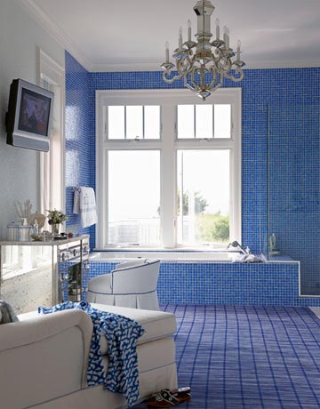 Gạch kính màu xanh hoàng gia và tường kính bao quanh đã được sử dụng cho phòng tắm sang trọng này