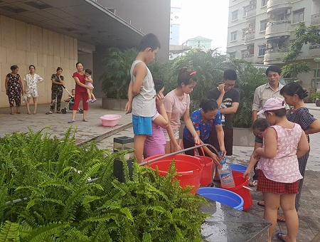 Người dân các tòa nhà chung cư tại Linh Đàm xếp hàng để hứng nước từ dưới mang lên nhà. Ảnh: N.Đ.T