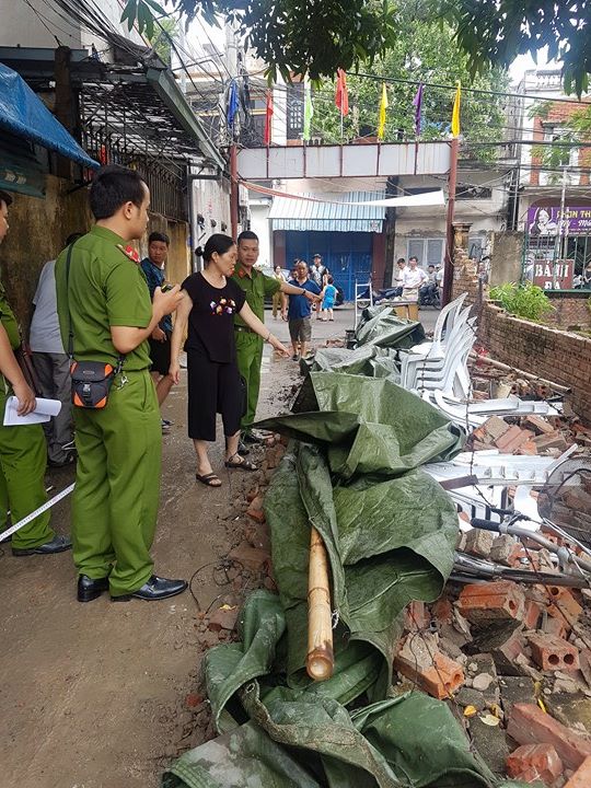 
Người dân trong ngõ 30 Nguyễn Thị Thuận đang kể lại vụ tường đổ sập làm bé Quang tử vong. Ảnh: ML
