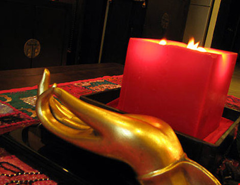 Một cây nến đỏ to cùng bàn tay vàng làm vật trang trí tại phòng khách