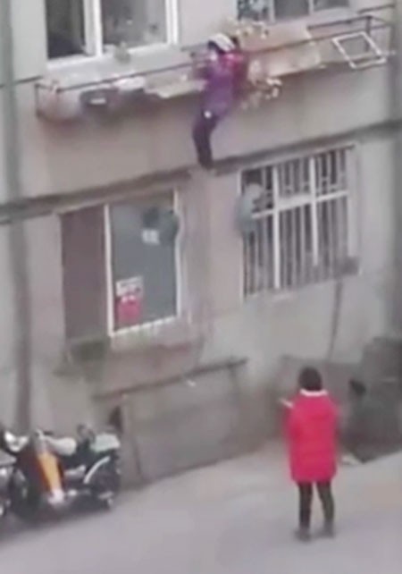 Bé gái đu bám khó khăn để trèo lên.