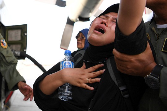 Một phụ nữ đợi sơ tán ở Palu. Ảnh: Reuters