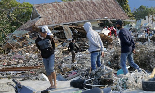 Người dân kiểm tra thiệt hại và tìm kiếm người sống sót tại bãi biển Talise, thành phố Palu, hôm 1/10. Ảnh: AP.