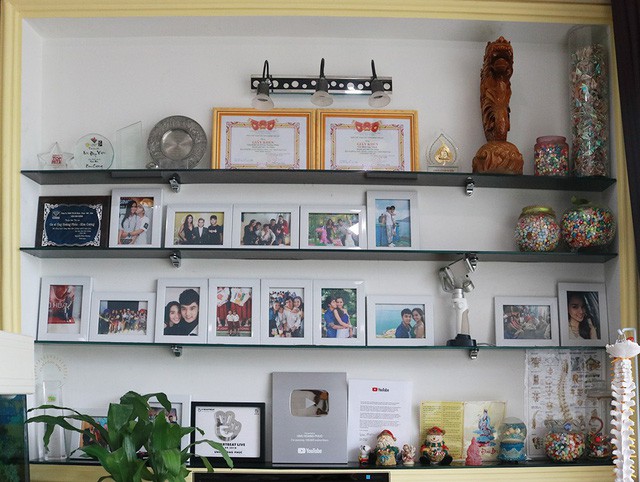 
Góc rộng trong phòng khách được ưu tiên trưng bày những hình ảnh của hai vợ chồng và các con. Những kỷ niệm chương và giải thưởng âm nhạc cũng được bày trí tại đây.
