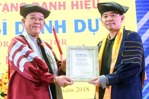 Phó giáo sư Ngô Viết Liêm (phải) nhận bằng tiến sĩ danh dự của Đại học Kinh tế TP HCM. Ảnh: ueh.edu.vn