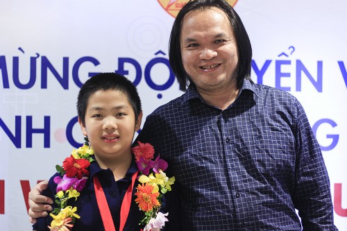 Trịnh Anh Minh c&ugrave;ng thầy gi&aacute;o Trần Phương trong buổi lễ ch&uacute;c mừng th&agrave;nh t&iacute;ch của đo&agrave;n Việt Nam tại s&acirc;n bay Nội B&agrave;i tối 4/10. Ảnh: Dương T&acirc;m