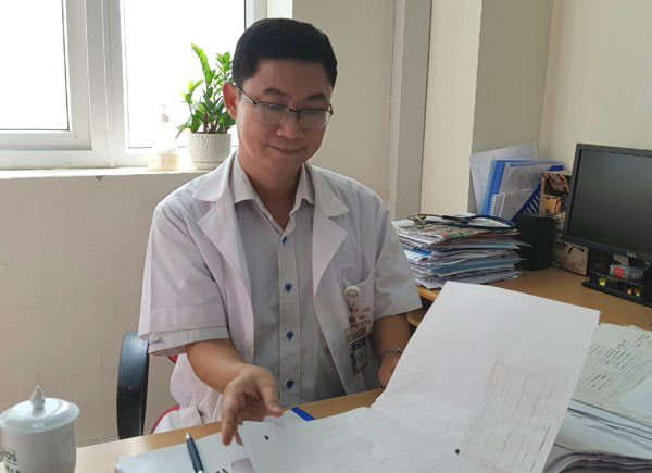 TS.BS Lê Thanh Đức lật giở hồ sơ bệnh nhân ung thư vú đang điều trị tại khoa