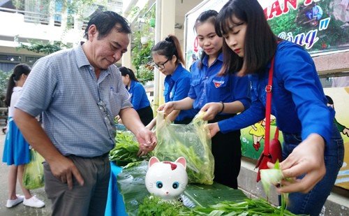 Giáo viên bỏ tiền vào con heo đất khi mua rau. Ảnh: Thạch Thảo.