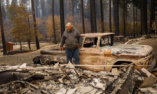 Một người dân ở hạt Butte đứng cạnh đống tro tàn do đám cháy rừng gây ra với ngôi nhà của mình. Ảnh: CNN.