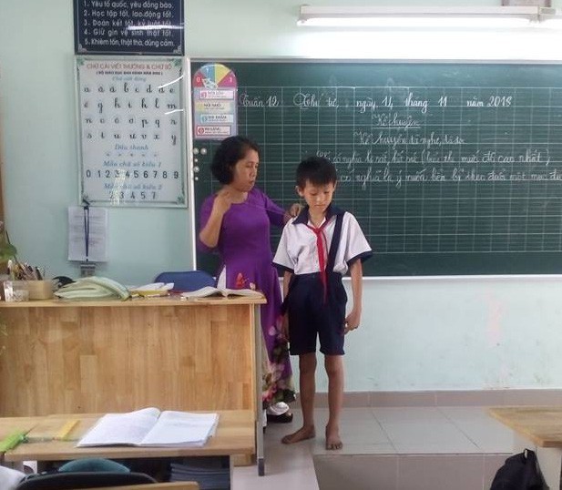 Cô Huỳnh Thị Thanh Phương khâu lại đai áo cho học trò