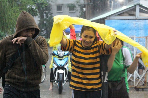 Học sinh TP HCM sau giờ tan học trong một cơn mưa lớn. Ảnh: Phạm Phúc.