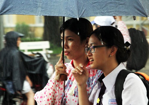 Học sinh THPT Nguyễn Thị Minh Khai (TP HCM) tan học trong cơn mưa. Ảnh: Mạnh Tùng.