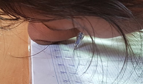 C&ocirc; b&eacute; nắn n&oacute;t từng n&eacute;t chữ. Ảnh: Ph&uacute;c Hưng.