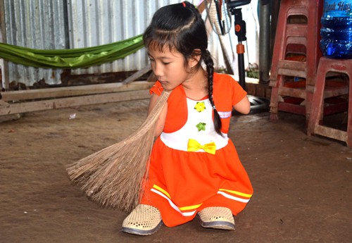 Thảo gi&uacute;p b&agrave; qu&eacute;t nh&agrave; ngo&agrave;i giờ học. Ảnh: Ph&uacute;c Hưng.