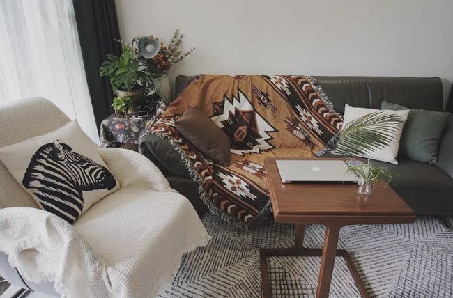 Góc tiếp khách ấm cúng với sofa, ghế bành và thảm trải sàn.