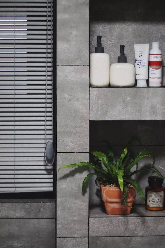 Tường phòng tắm được thiết kế thêm kệ hốc để tăng thêm diện tích lưu trữ đồ và đặt được chậu cây xanh.