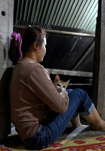 Nary ôm mèo, ngồi trong căn nhà gỗ đơn sơ ở ngoại ô Campuchia hôm 2/10. Ảnh: AFP.