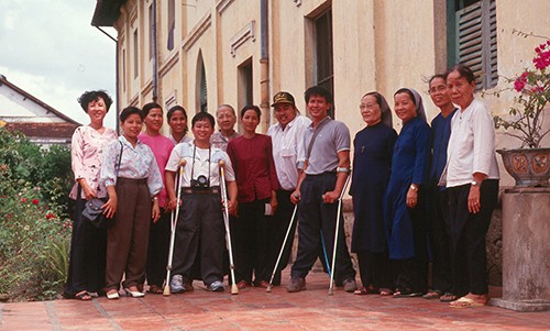 Nguyễn Quốc Túy (áo trắng, đội mũ) đứng cạnh mẹ Nguyễn Thị Bé (áo đỏ) cùng những người bạn và các xơ tại cô nhi viện ở Sa Đéc năm 1993. Ảnh: Nhân vật cung cấp