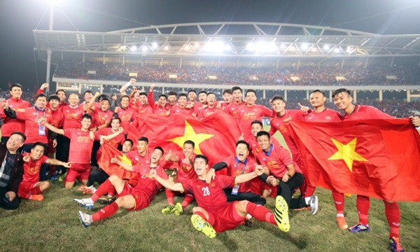 
Cầu thủ Việt Nam diện đồng phục áo đỏ và mang cờ Tổ quốc sau khi lên ngôi vô địch.

