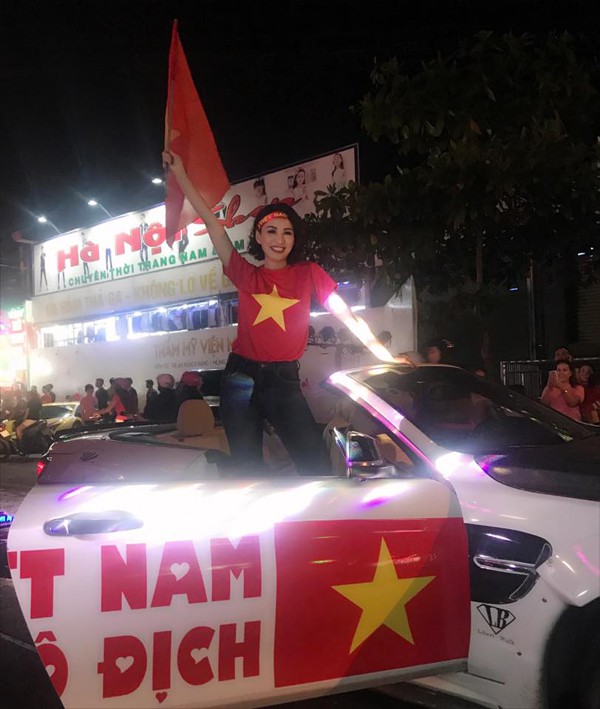 
Hoa hậu Ngọc Diễm đứng lên chiếc ôtô với dòng chữ Việt Nam vô địch để vẫy cờ chúc mừng chiếc cup AFF mà các cầu thủ vừa đoạt được.
