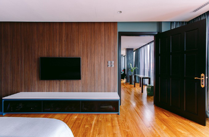 Phòng ngủ chính có nội thất mang sắc xanh dương và xanh lá dịu nhẹ.