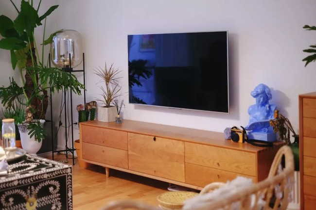 Kệ đặt ti vi được thiết kế khá đơn giản với chất liệu gỗ cùng tông màu với sàn tăng thêm sự kết nối hài hòa cho phòng khách.