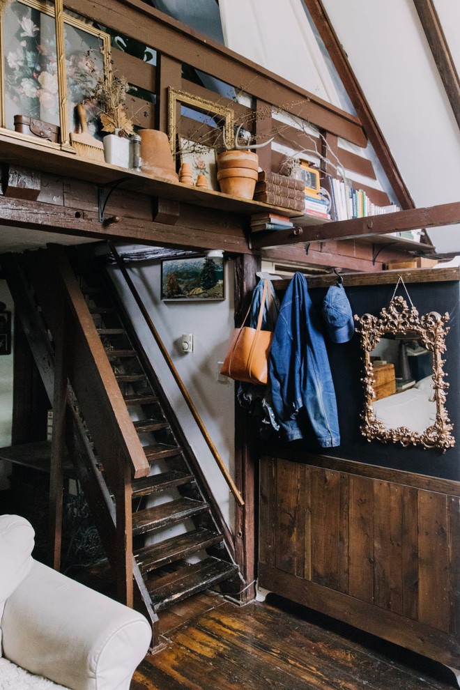 Cạnh sofa được bố trí cầu thang gỗ cùng tông màu với sàn tạo sự kết nối liền mạch đầy ấn tượng cho không gian thêm cổ kính.