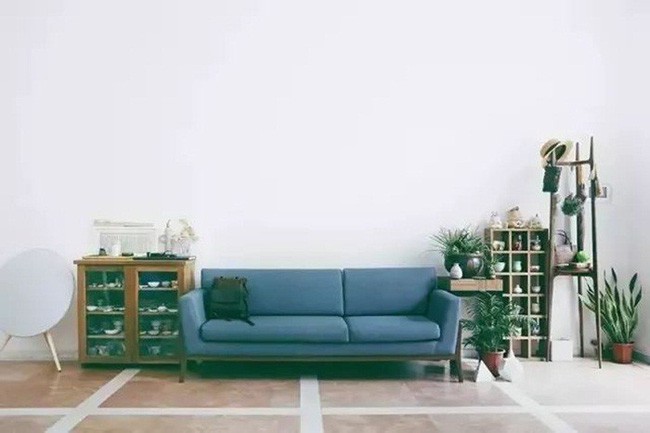 Chiếc sofa cũng được thiết kế nhỏ nhắn, vừa vặn với sắc màu nền nã nhưng không kém phần sinh động giữa bức tường trắng và cây xanh. Gốm cũng được đặt xung quanh các kệ cạnh sofa.