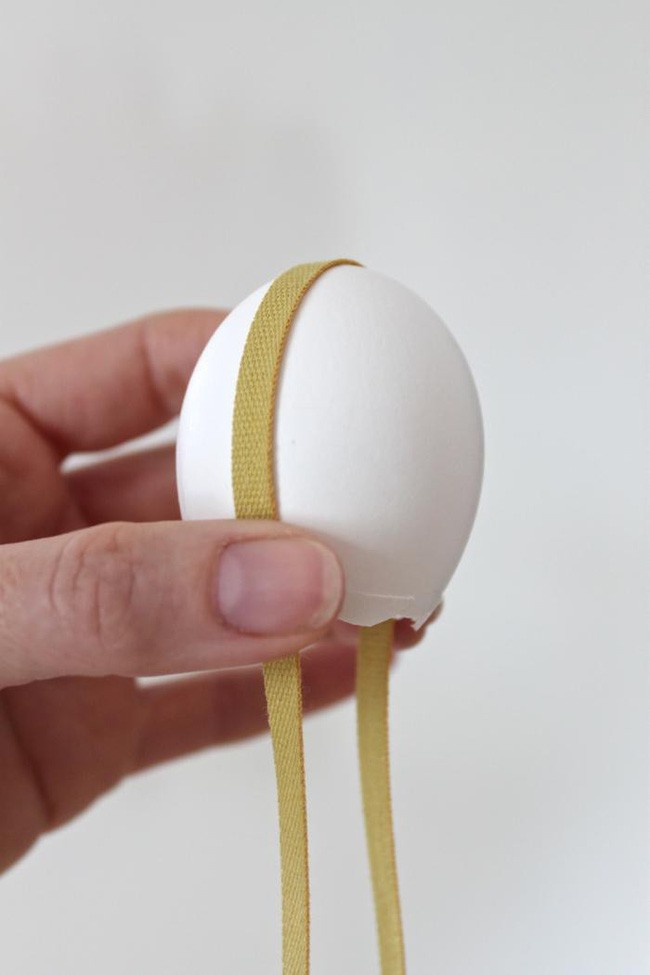 Dùng keo để cố định dây xung quanh quả trứng và treo lên phía trên khung cửa.