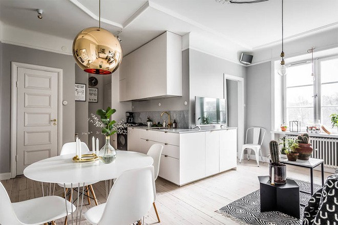 Góc ăn uống không chiếm quá nhiều diện tích nhưng vẫn khiến mọi người luôn cảm thấy thoải mái khi ngồi ở đây, thưởng thức những món ăn đơn giản. Nội thất được sử dụng ưu tiên chọn lựa gam màu trắng cùng đường nét mềm mại, tinh tế. Điểm nhấn của không gian ăn uống chính là đèn thả trần màu đồng sang trọng, gây ấn tượng đặc biệt cho góc nhỏ vốn đơn giản và gọn đẹp.