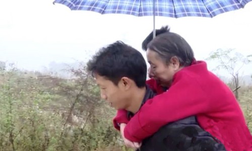 Wang Xianqiang cõng mẹ đi dạo. Ảnh: Weibo.